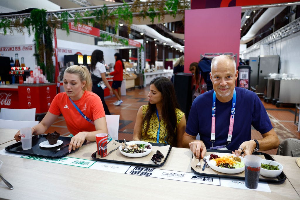 Drie mensen eten op de Olympische spelen in Parijs.