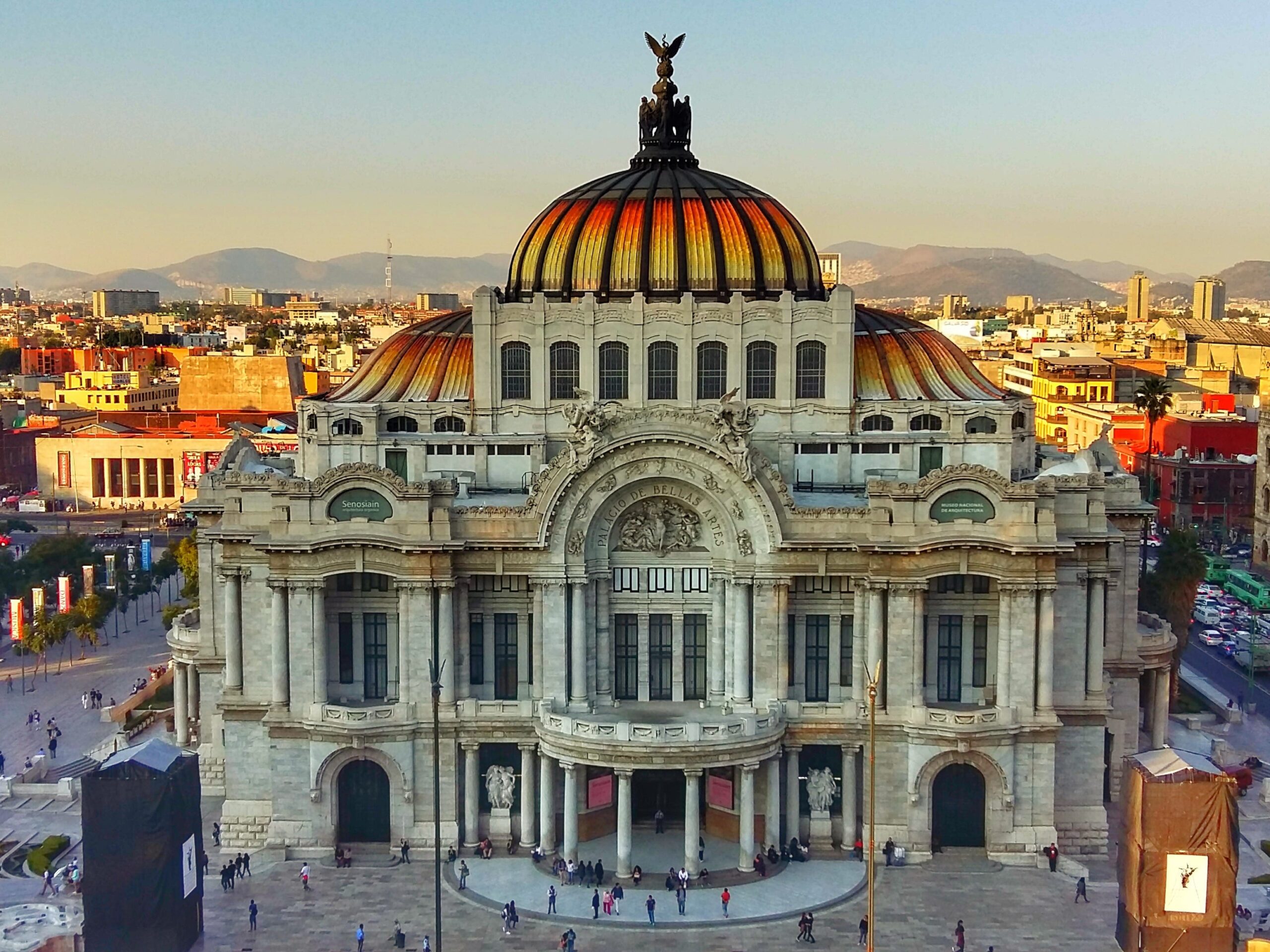 Een weids uitzicht op Palacio de Bellas Artes en omliggende straten met bergen op de achtergrond in Mexico-Stad.