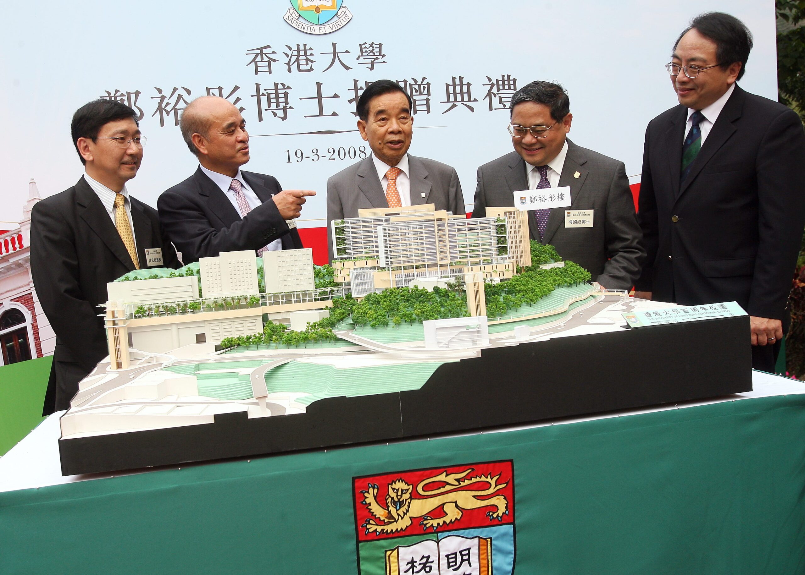 Cheng Yu-tung standing with two men on each side of him behind an architectural model.