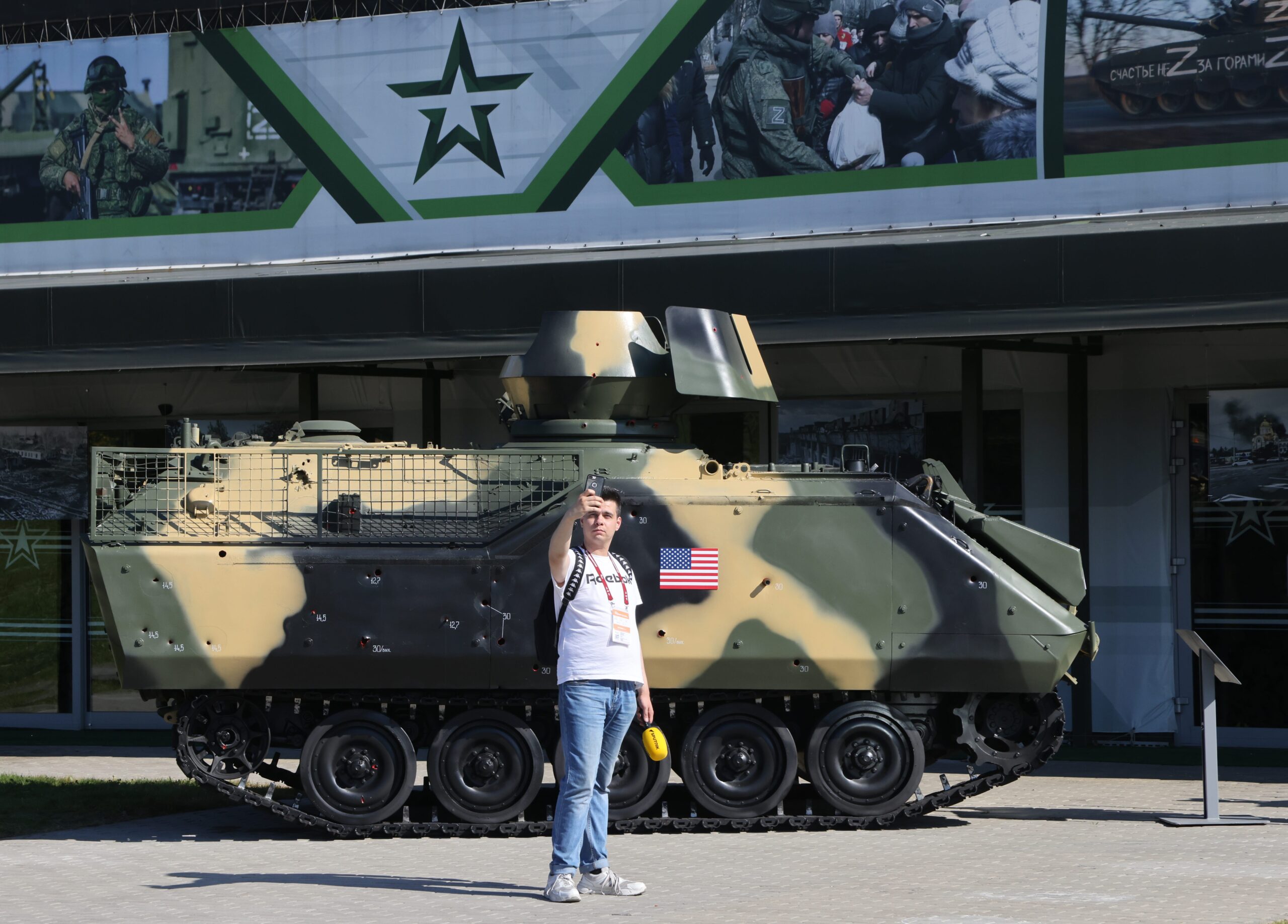 Een bezoeker neemt een foto van een in de VS gemaakte gepantserde personeelscarrier die werd buitgemaakt in Oekraïne, tentoongesteld op een tentoonstelling in Kubinka, Rusland.