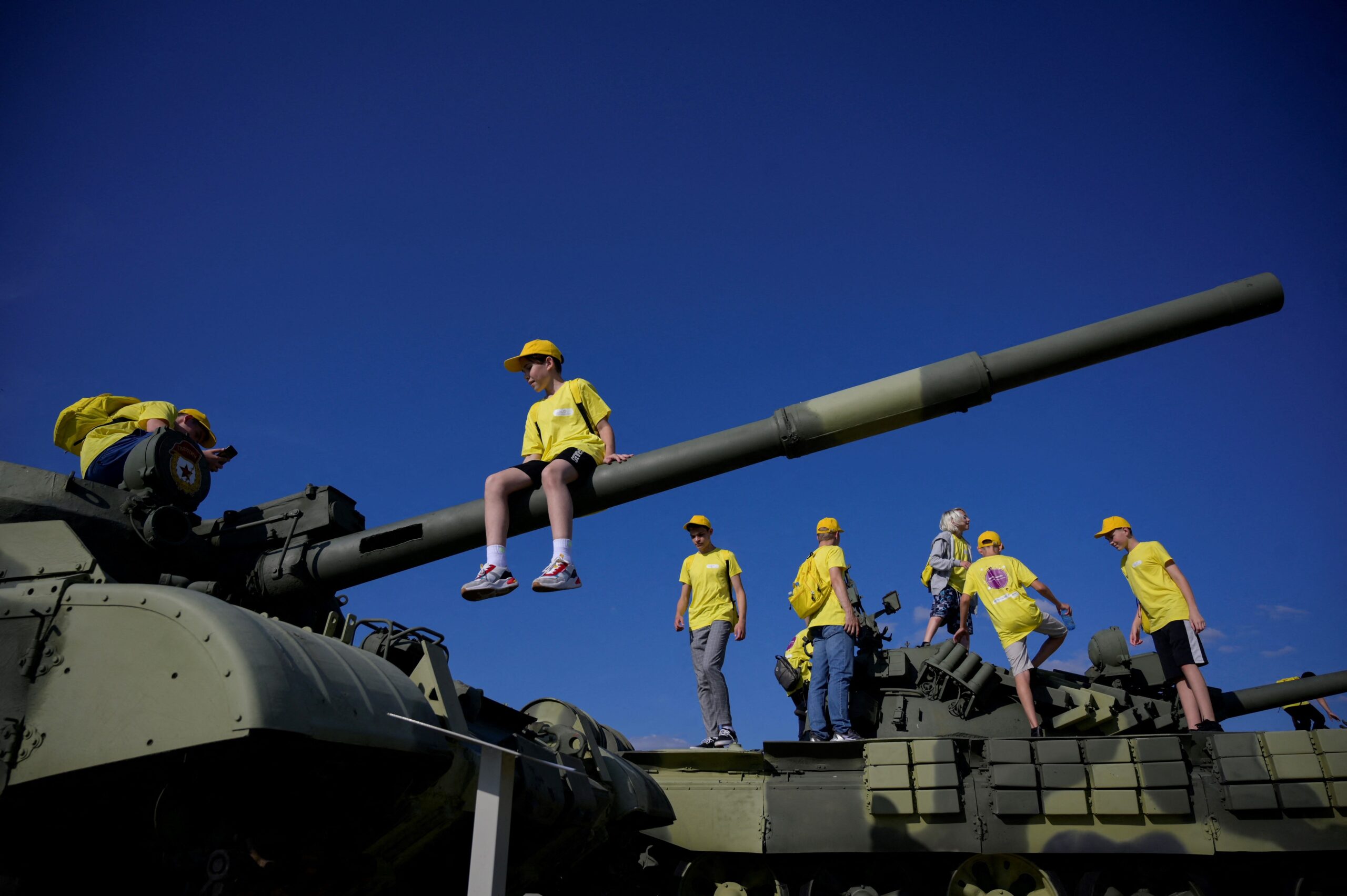 Kinderen klimmen bovenop een T-62M tank die wordt tentoongesteld in Patriot Park.