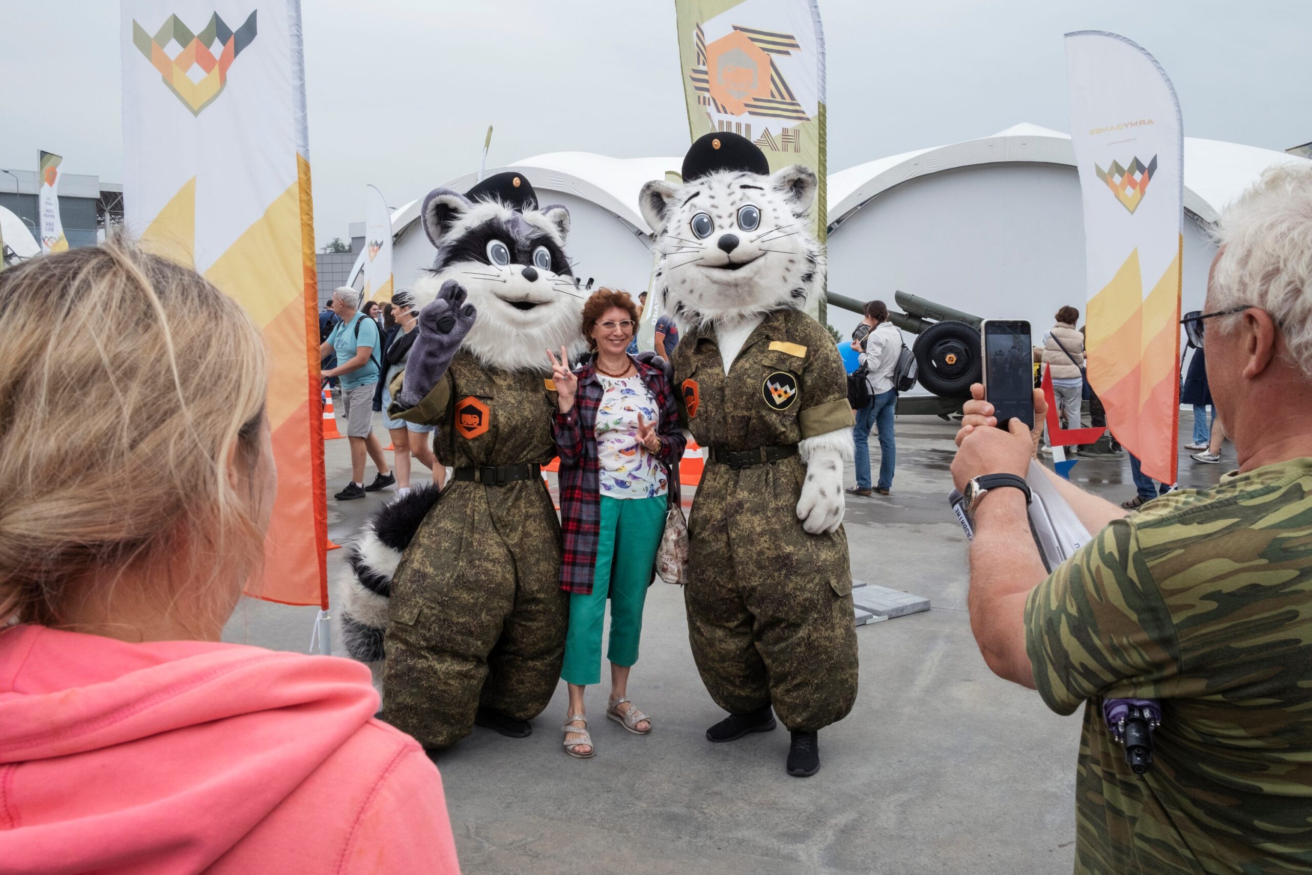 Entertainers in kostuum poseren voor een foto met een gast in Patriot Park.