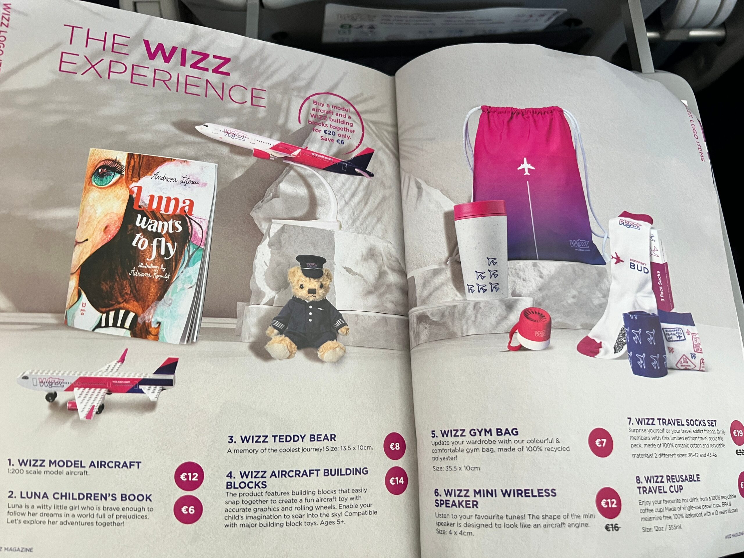 Een pagina van het Wizz Air-magazine met het aanbod van modelvliegtuigen, sokken, tassen en andere producten.