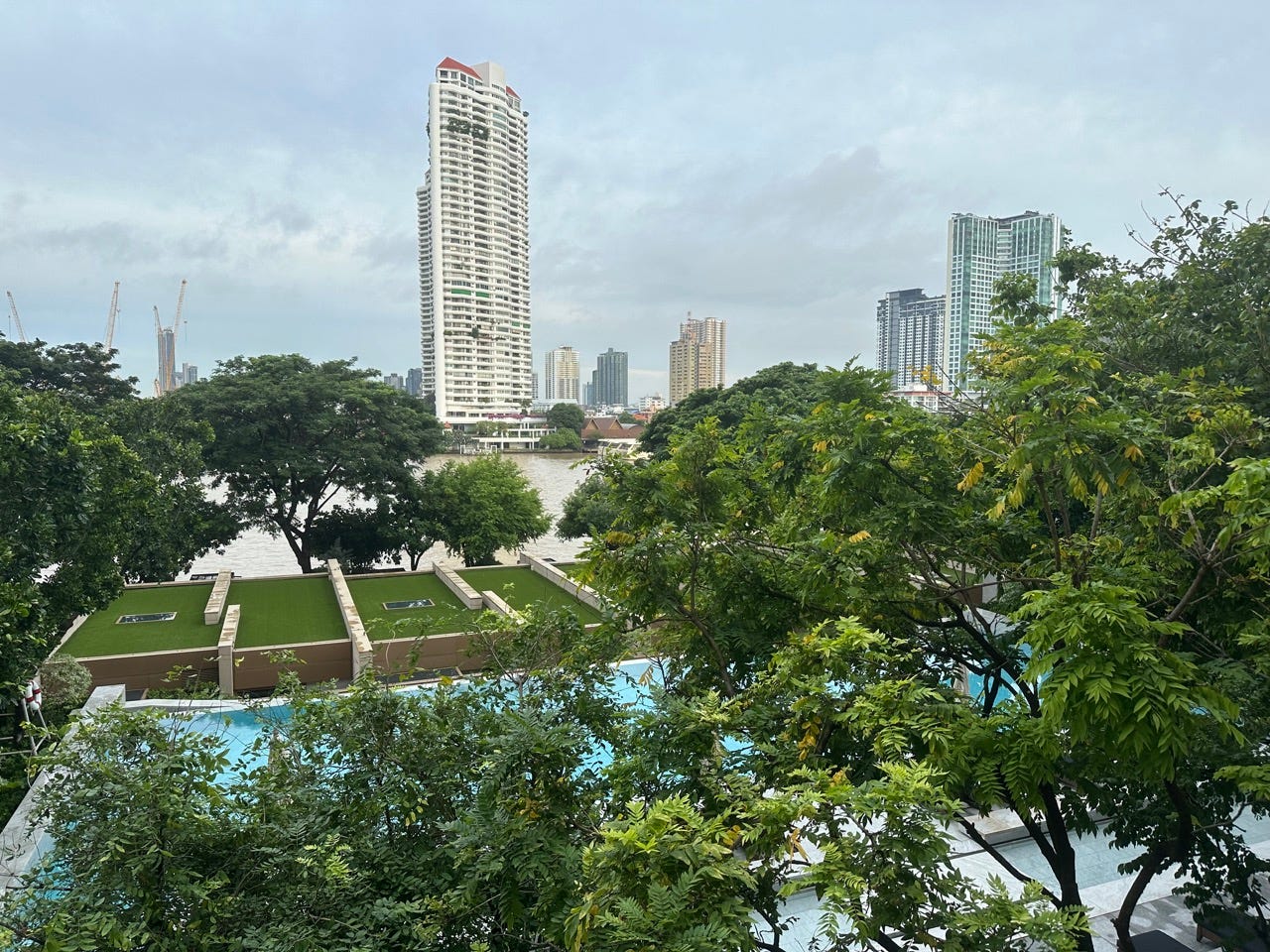 View of buildings and trees over water off of hotel room balcony 