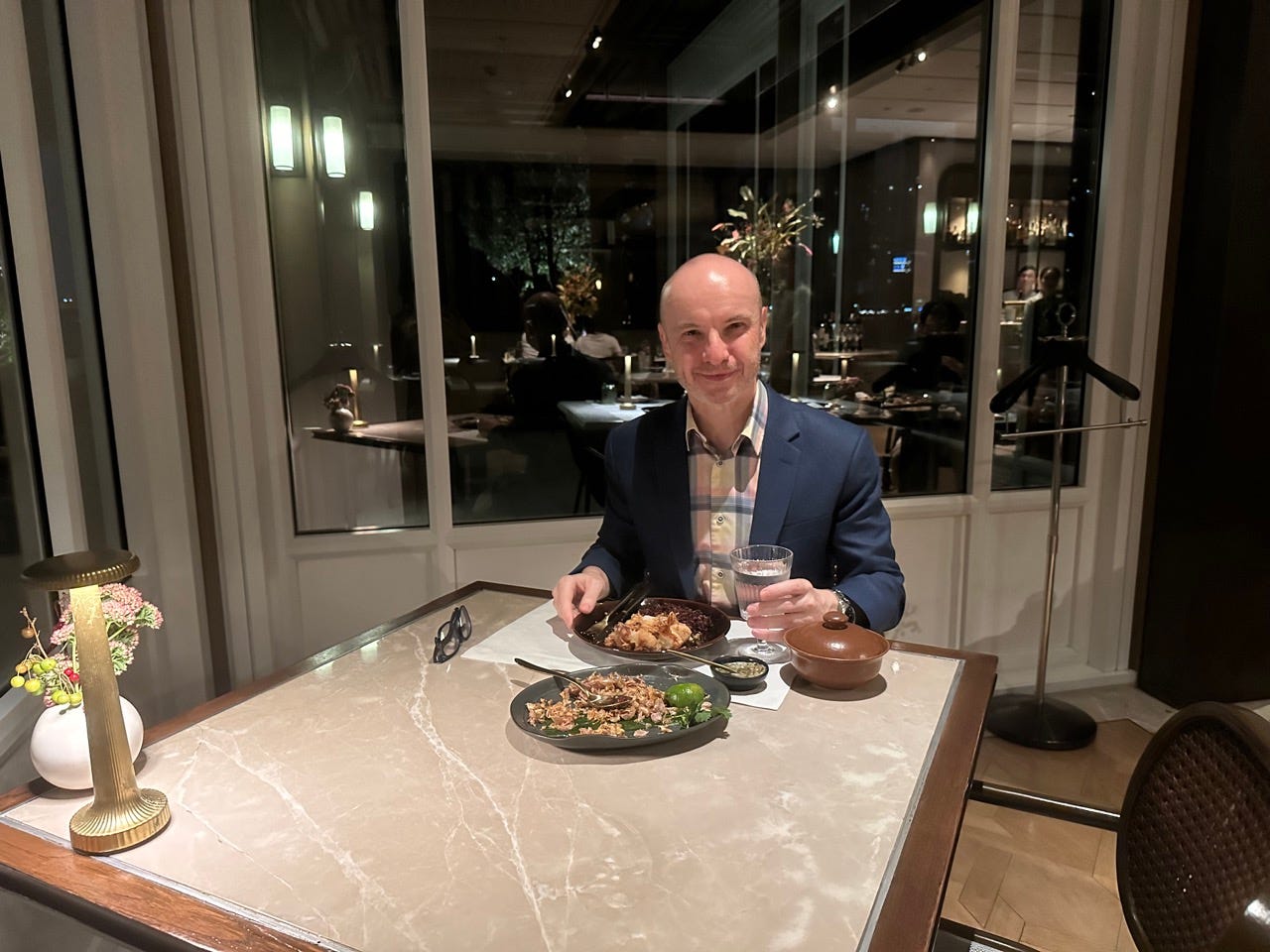 Author Paul Oswell sitting alone at table with meal in front of him 