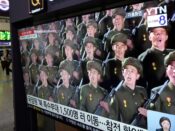 Een Noord-Koreaanse militaire parade op een tv-scherm in een treinstation in Zuid-Korea.