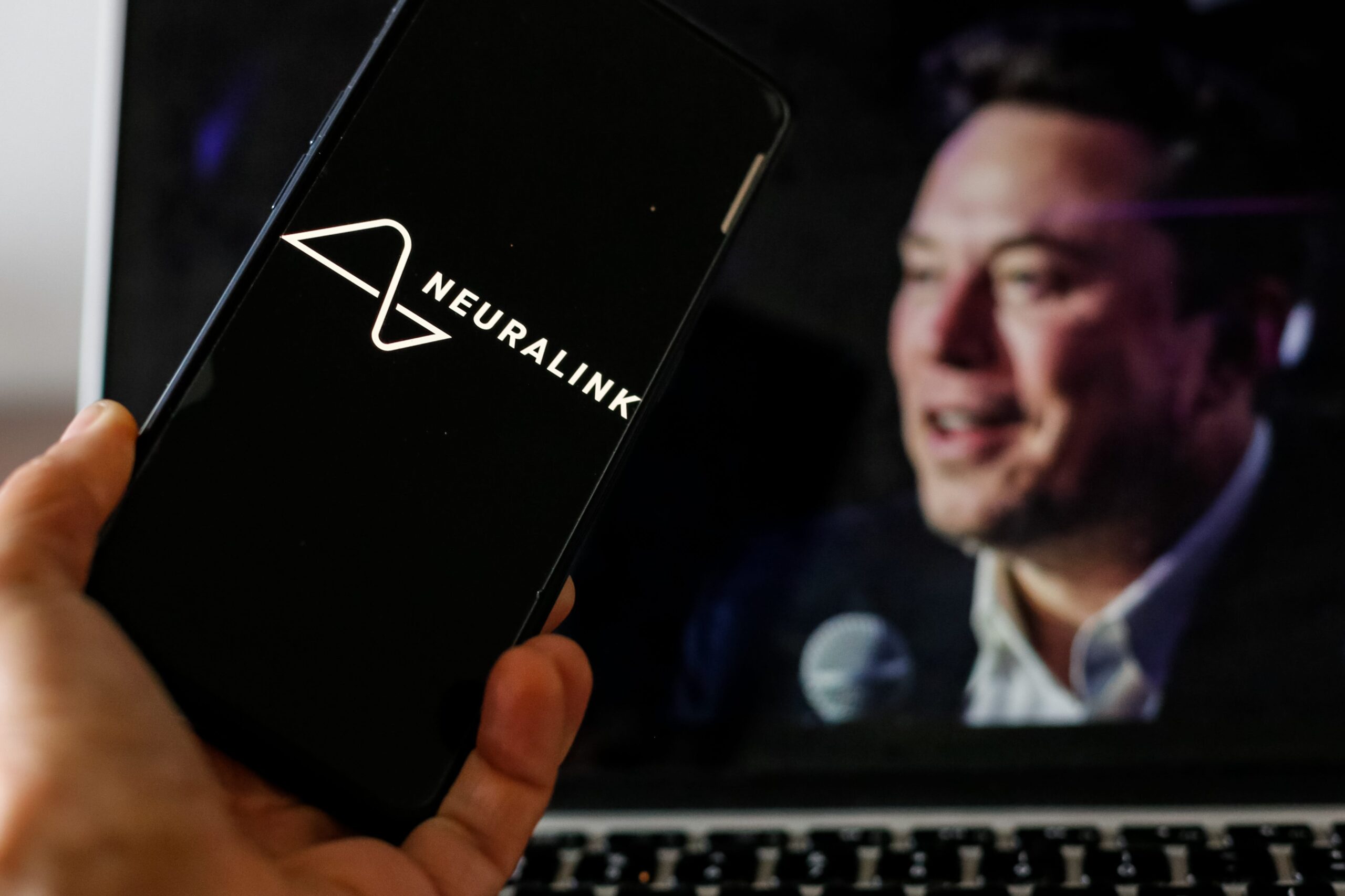 Neuralink logo with Elon Musk in background