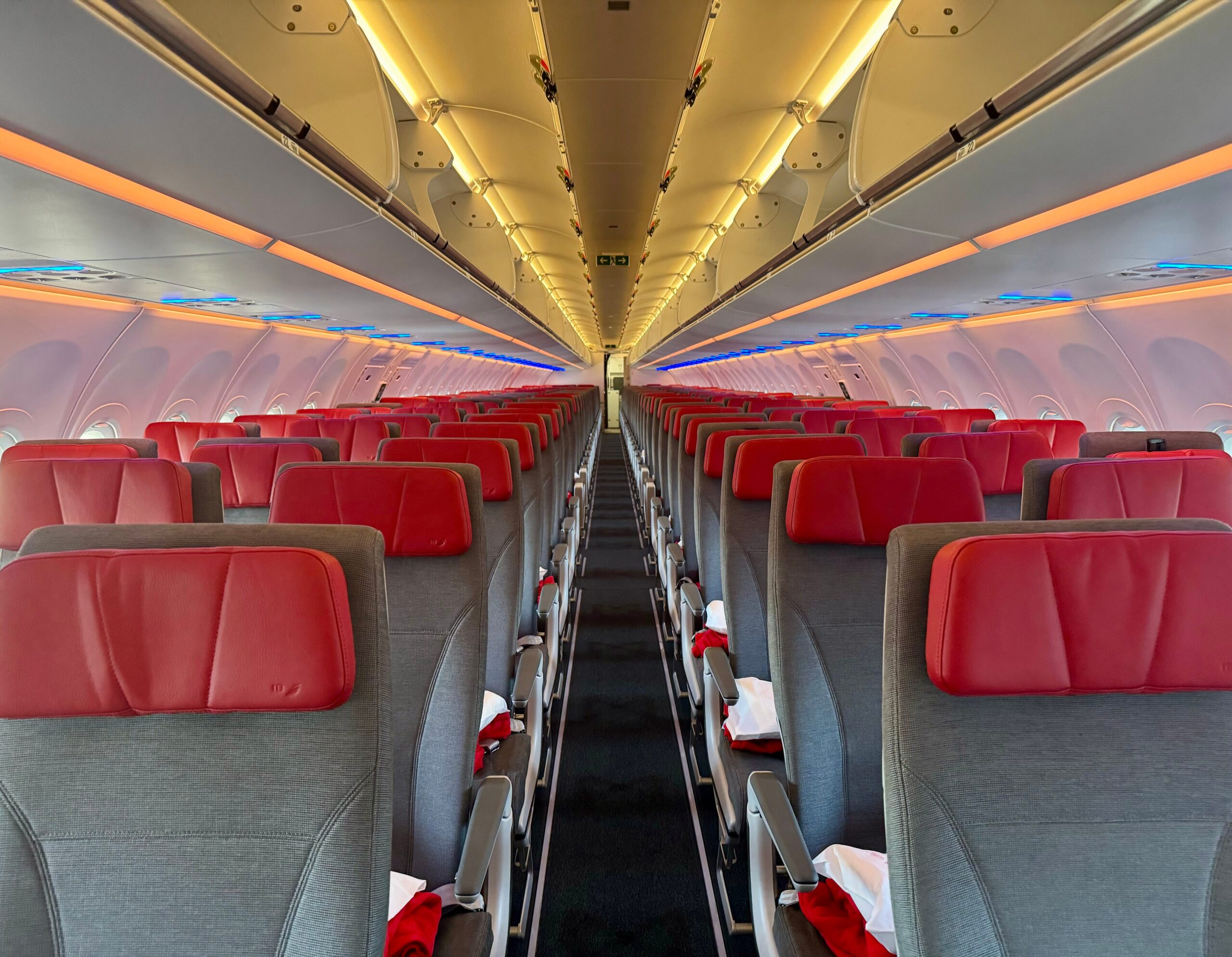 The economy cabin with grey seats and a red headrest on Iberia's A321XLR.