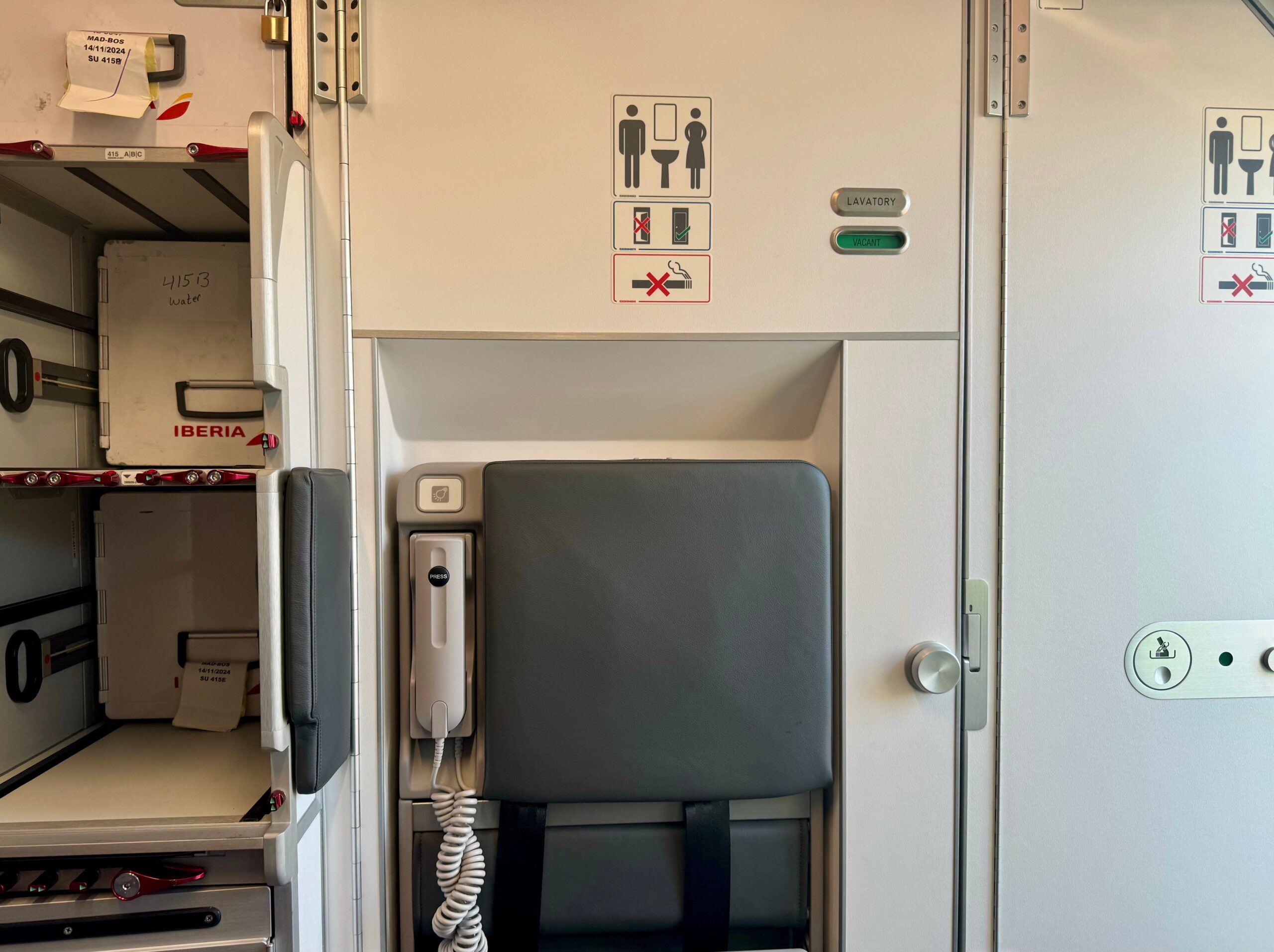 The lavatory at the aft of Iberia's A321XLR covered by a grey flight attendant jumpseat.