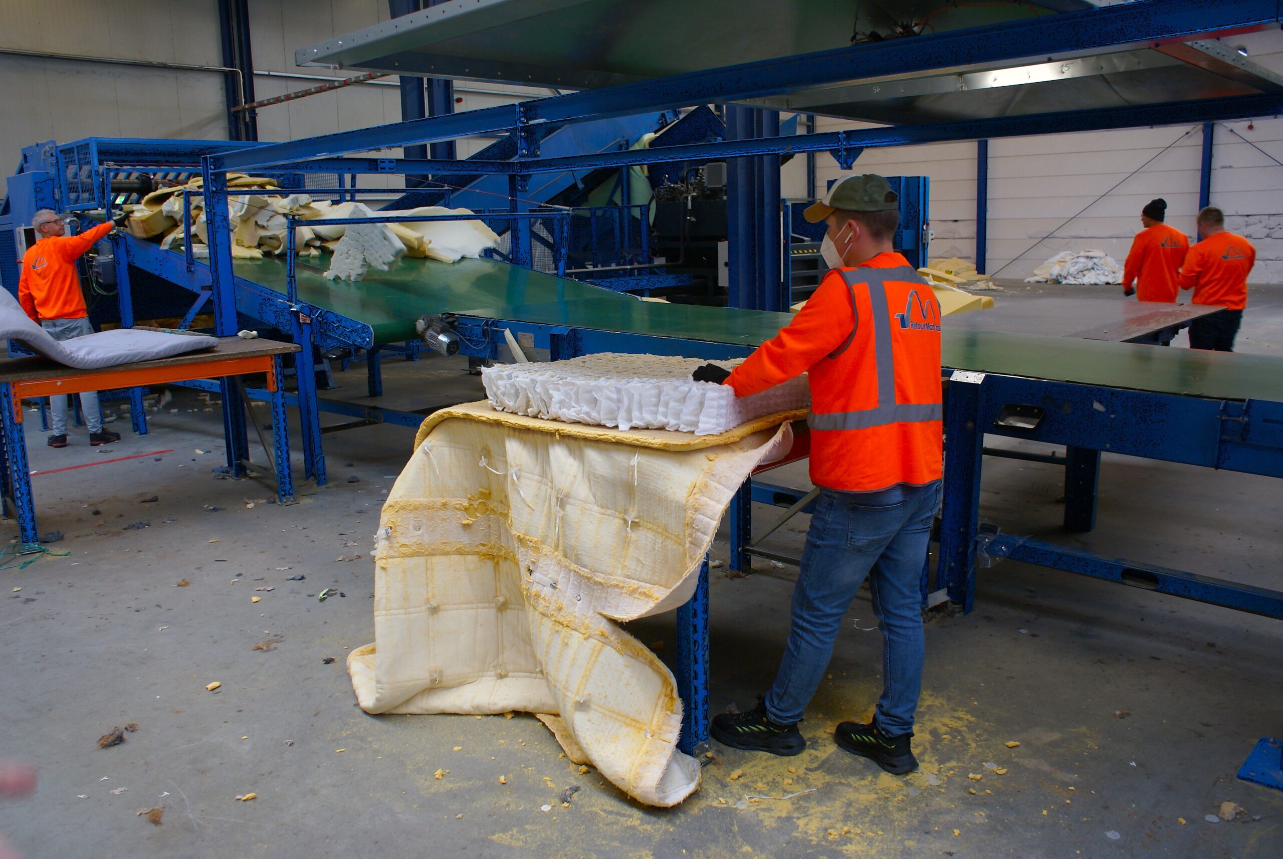 Een medewerker in Lelystad haalt een matras uit elkaar.