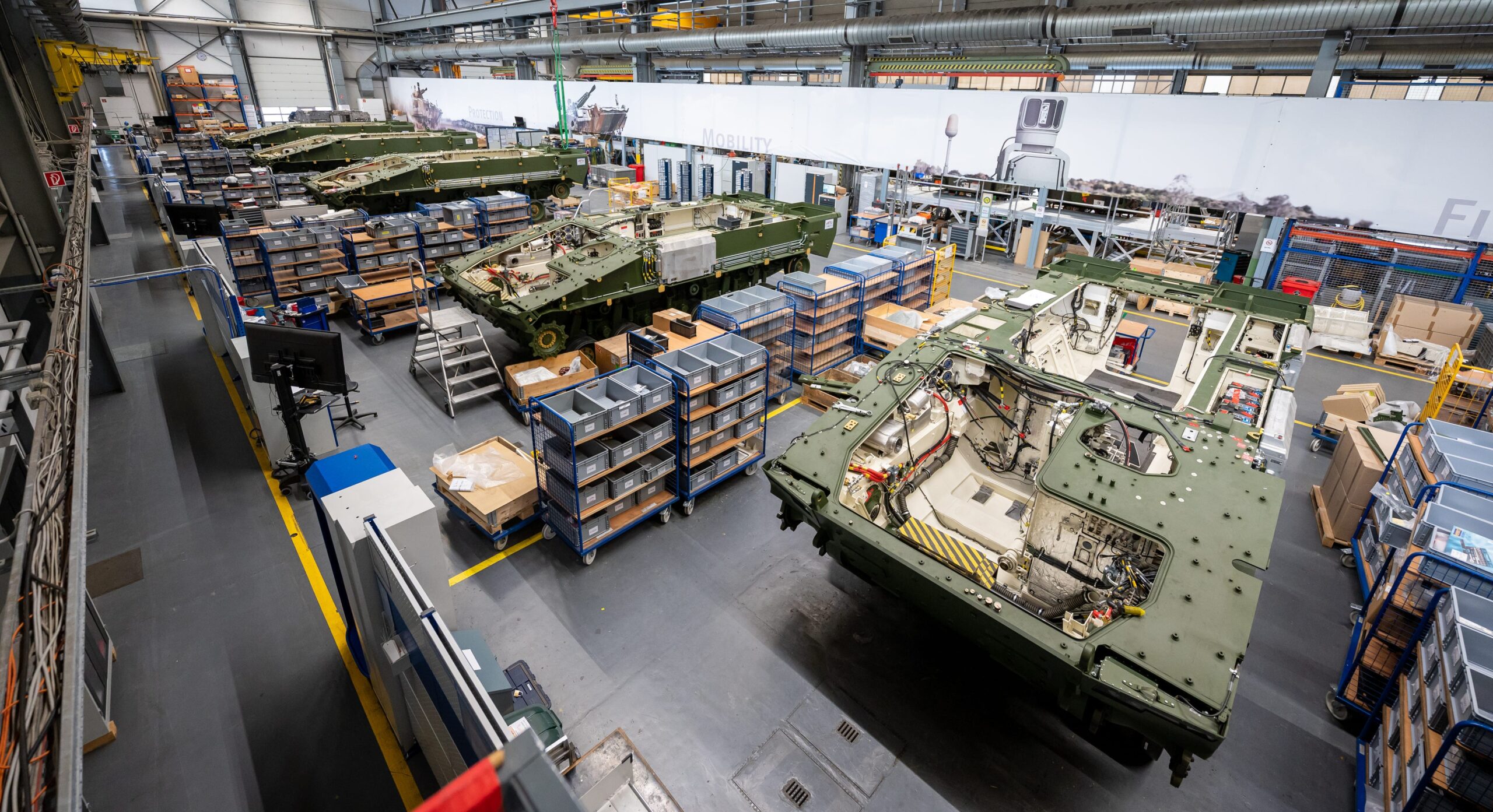 A line of Lynx infantry fighting vehicles mid-production are lined up in a Rheinmetall facility.