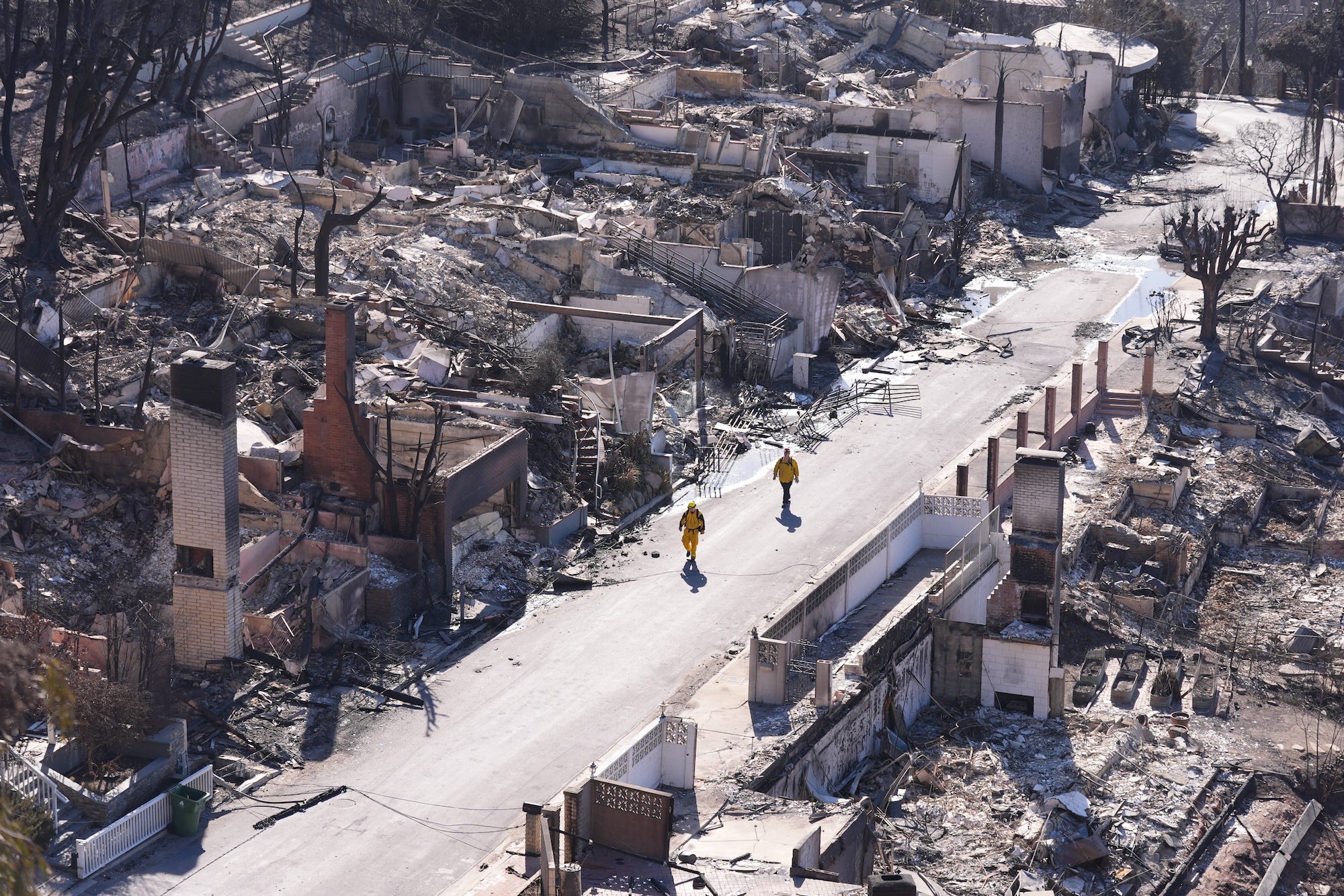 Firefighters walk through a burned neighborhood in Los Angeles.