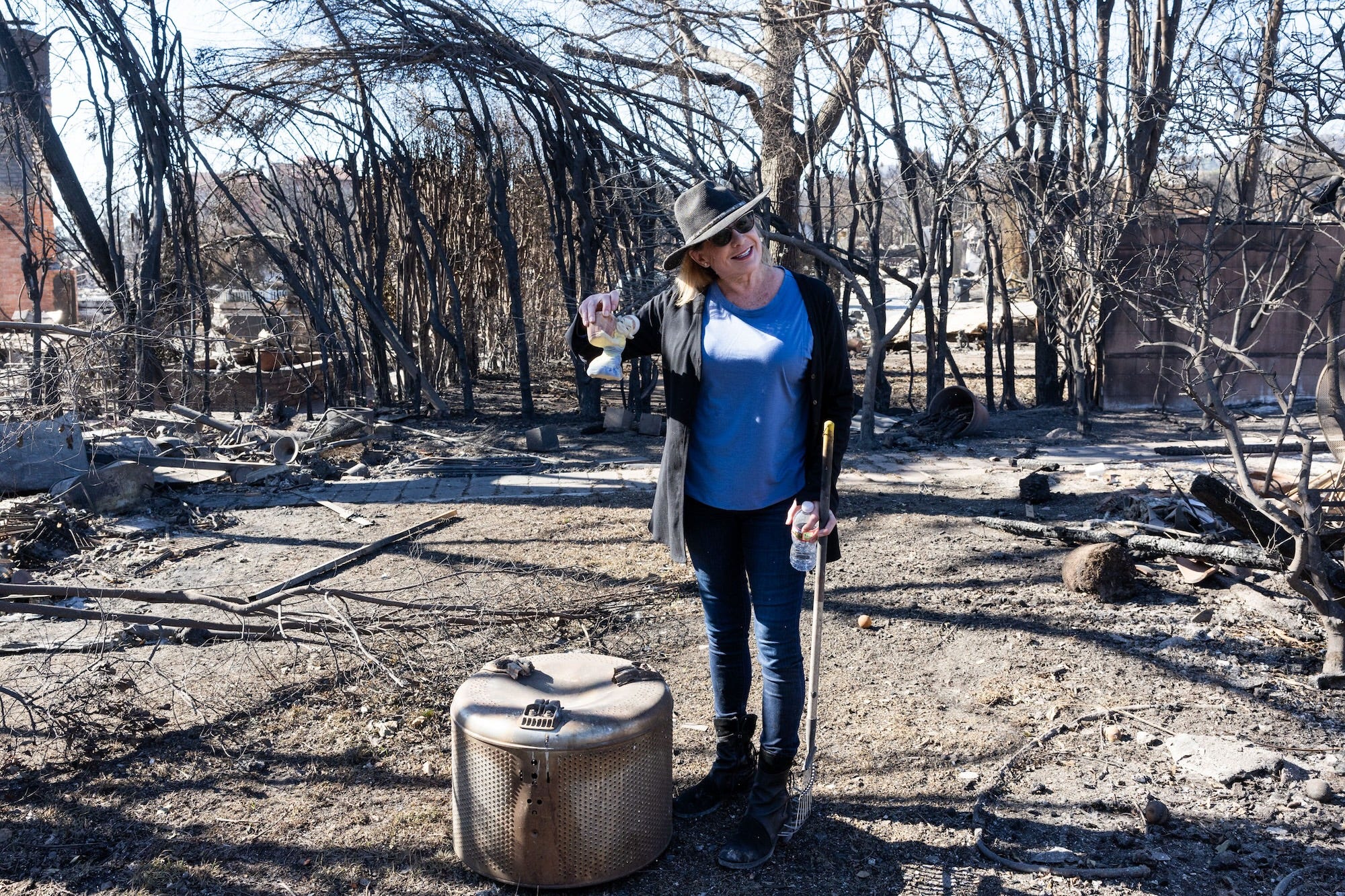 A local resident smiles as she finds her doll left from the ruins of scorched homes after the Palisades fire.