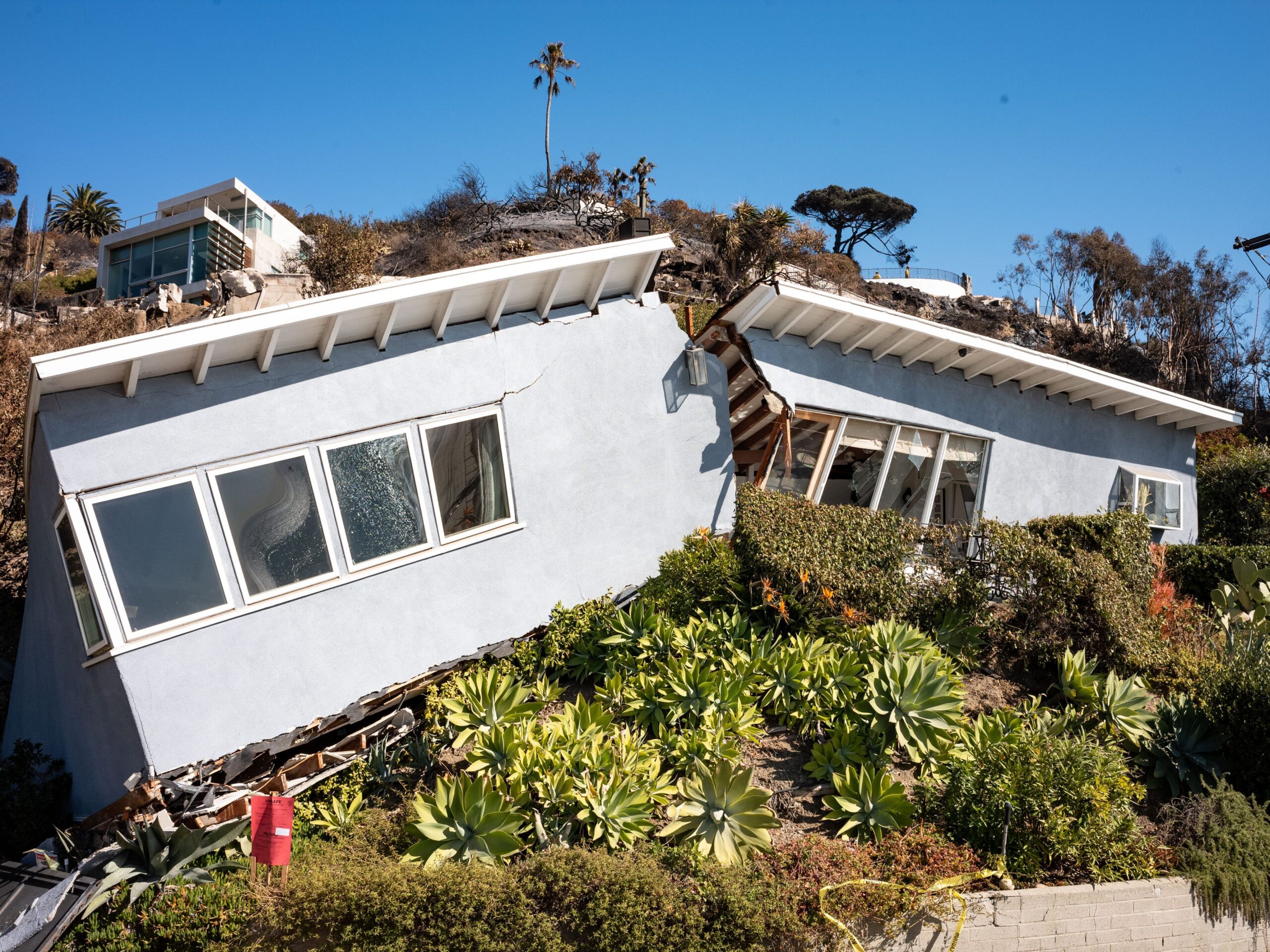 A home that was unaffected by the Palisades fire shown split in half.