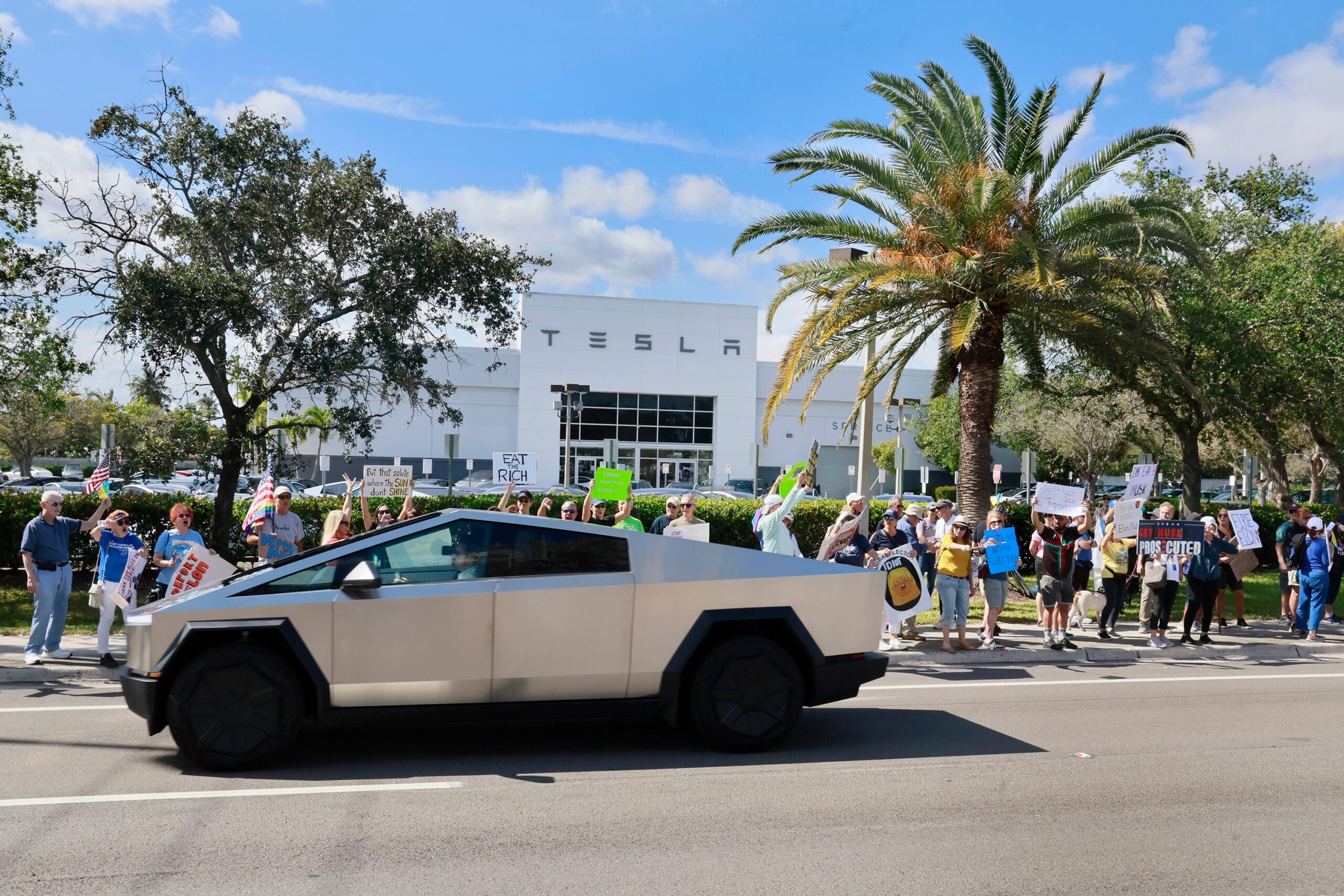 Cybertruck riding past Tesla dealership