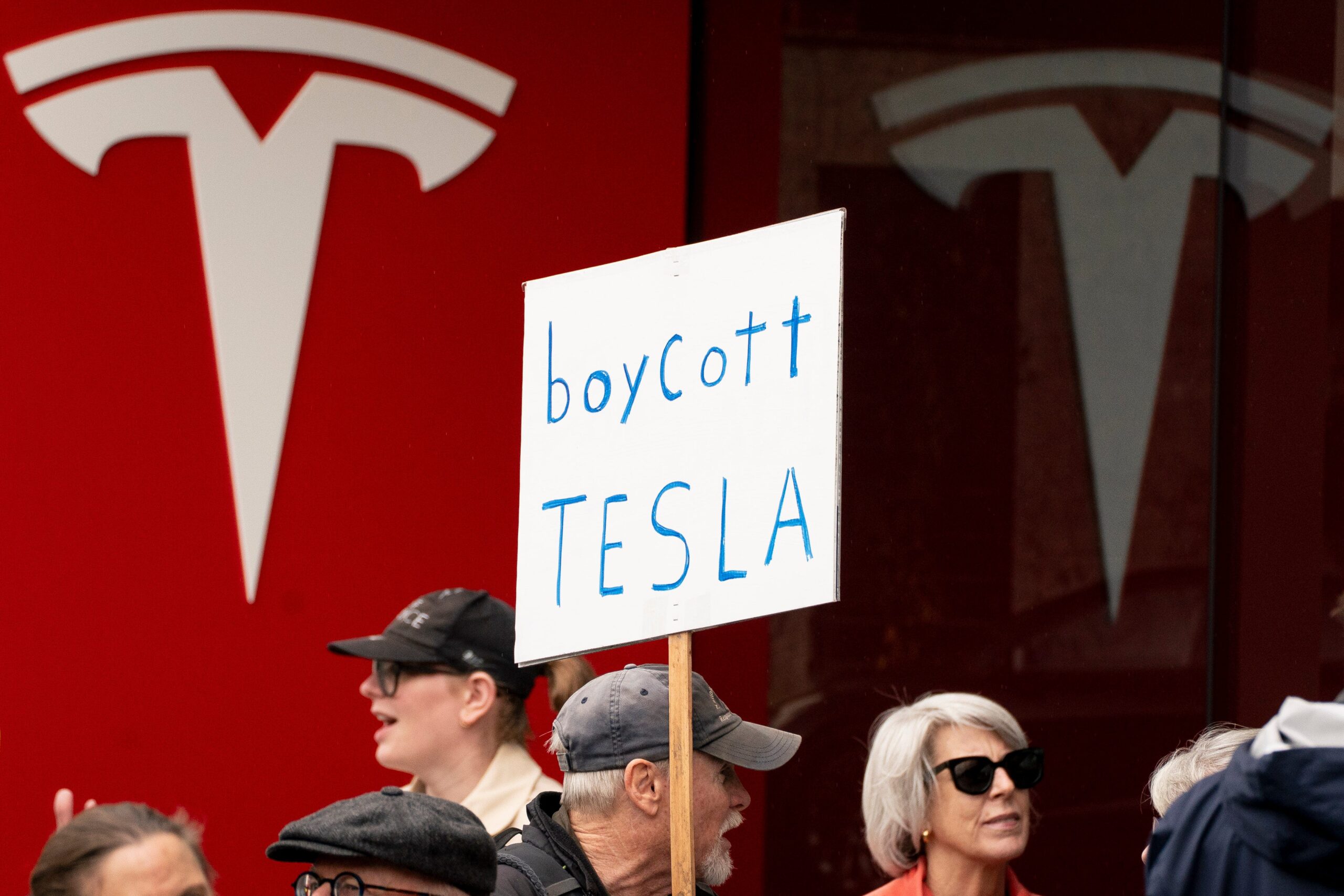 Boycott Tesla sign on poster with Tesla logo behind