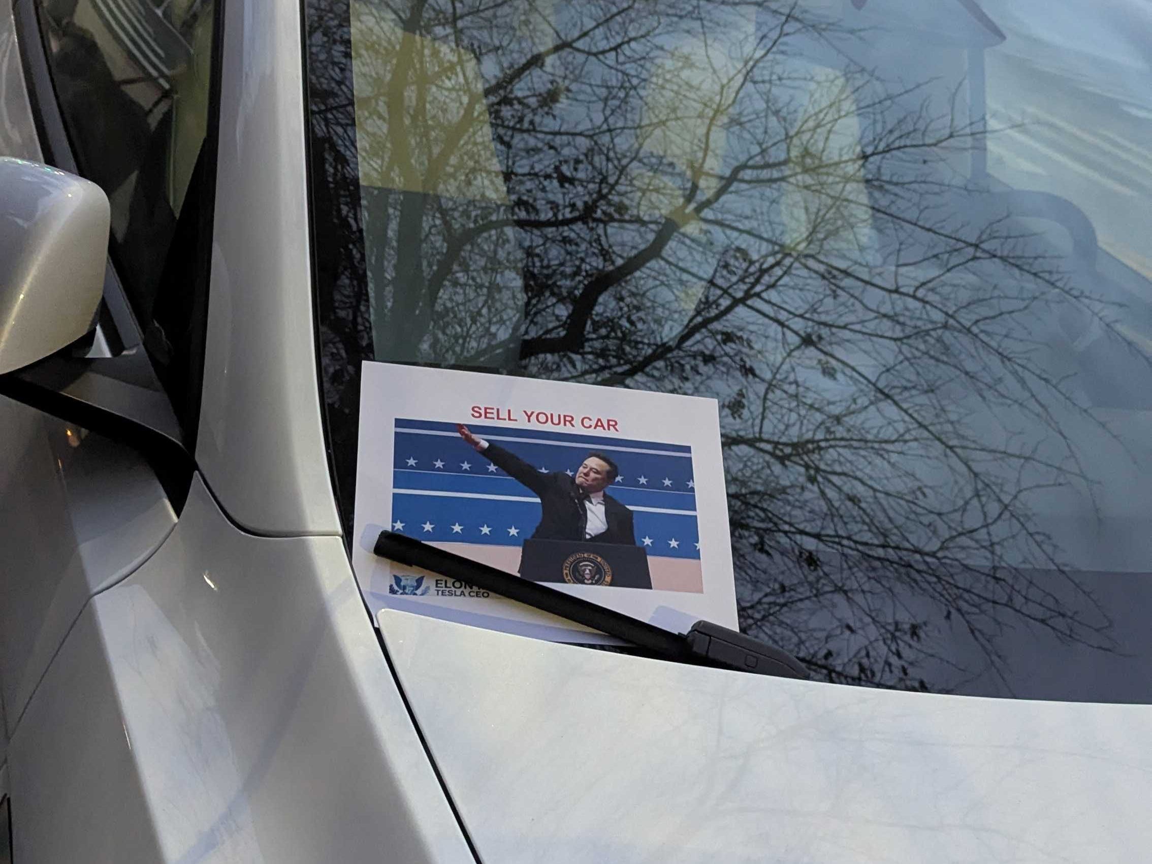 Windshield with paper that says sell your car