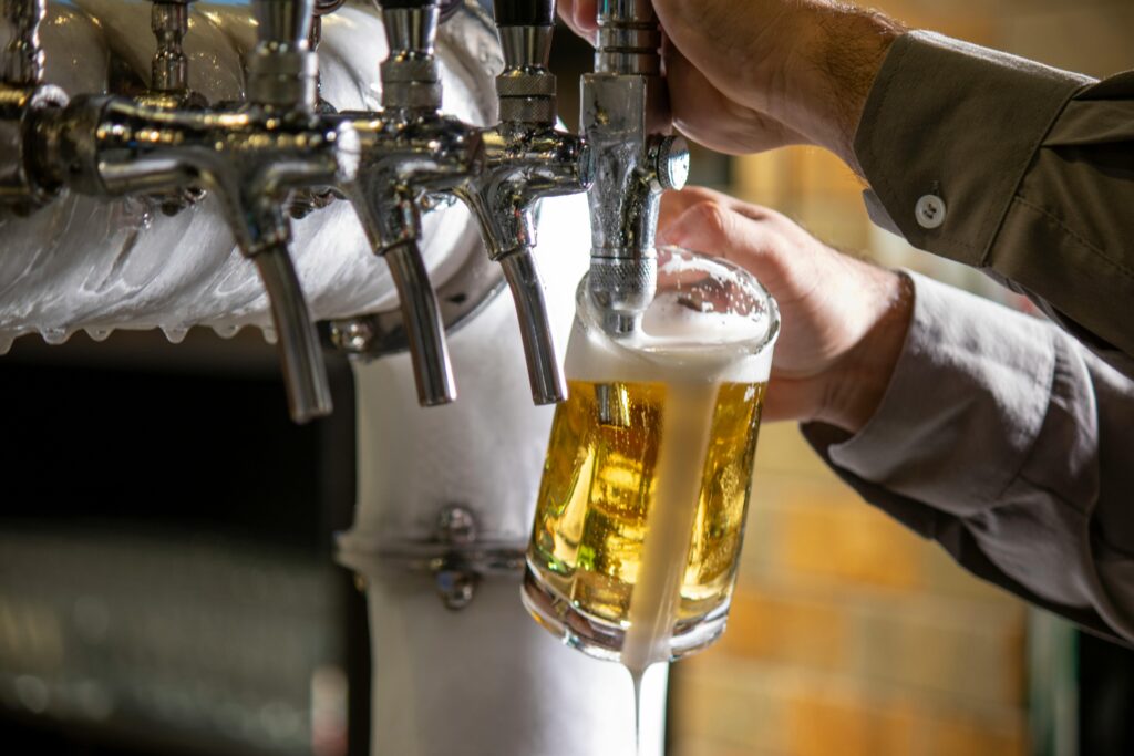 Een barman tapt een pint met bier.