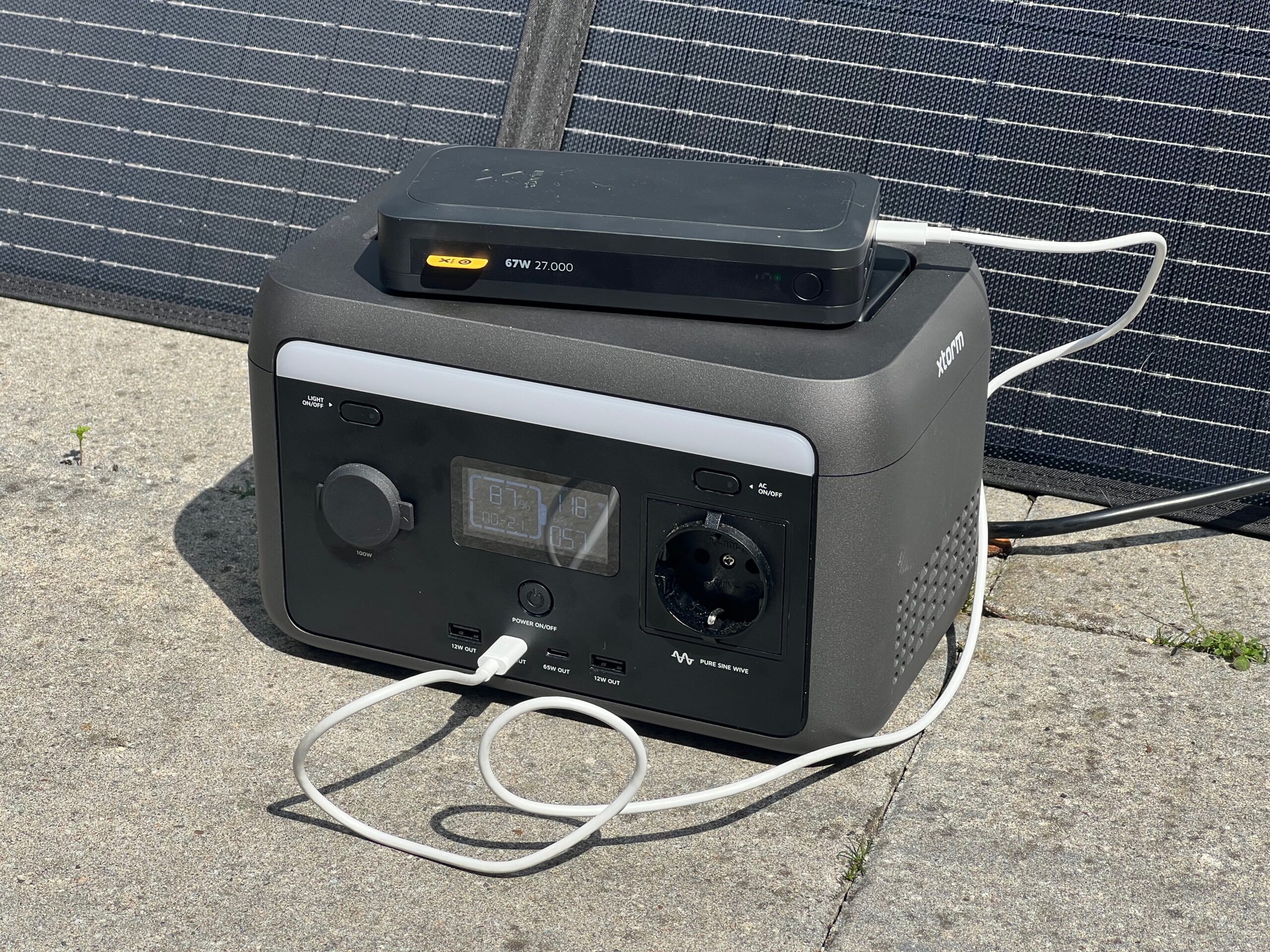 Draagbaar zonnepaneel en accu die een powerbank oplaadt.